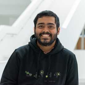 A smiling man appears indoors