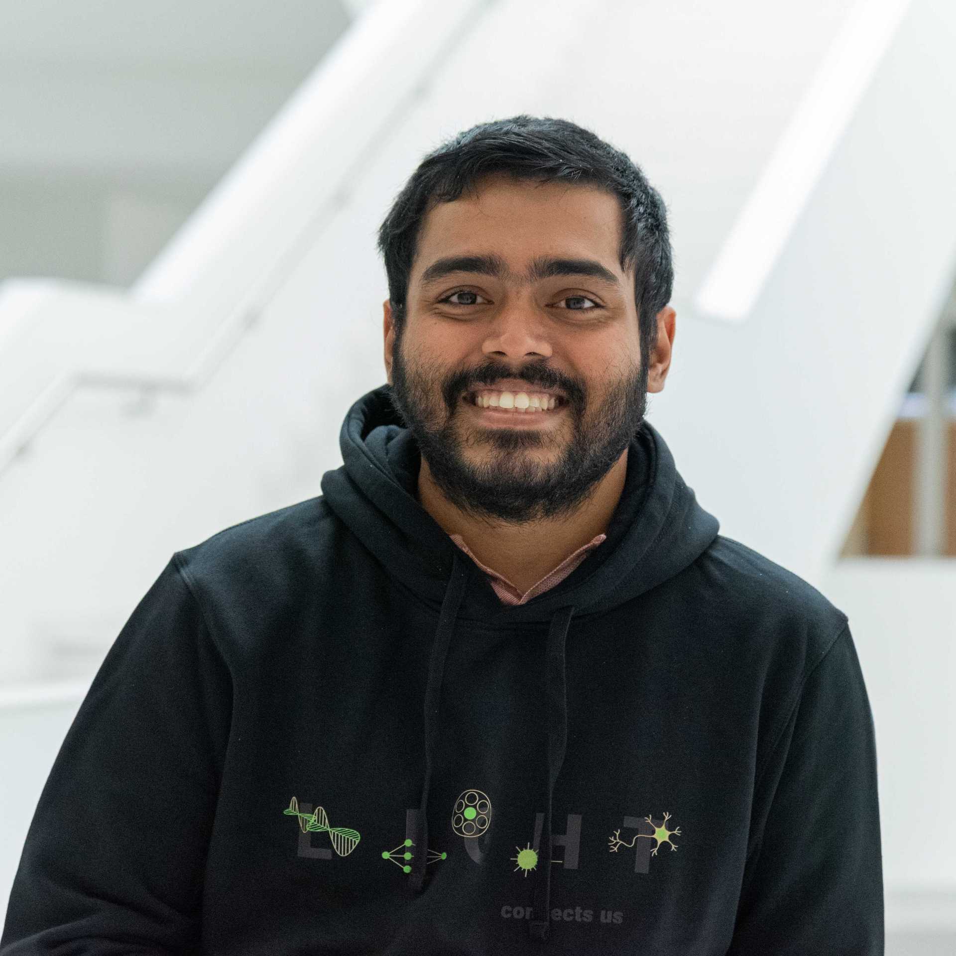 A smiling man appears indoors