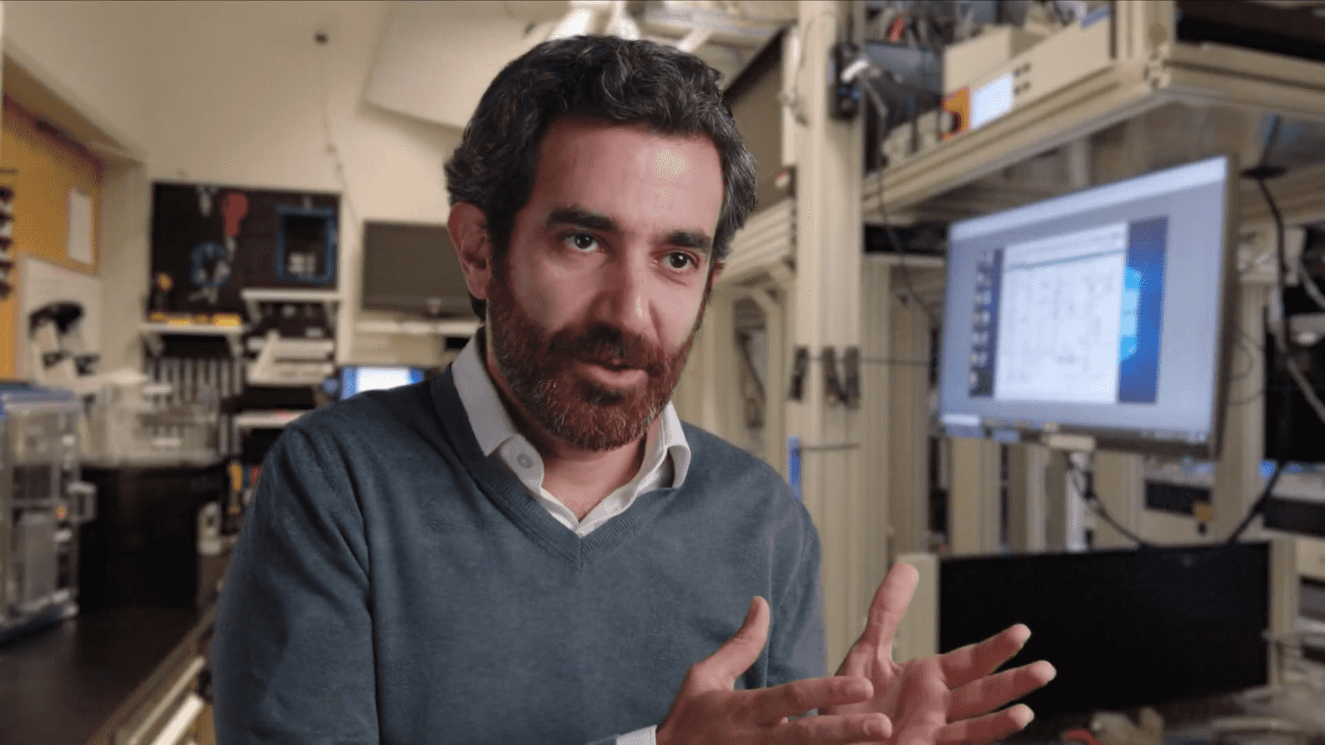 Mohammad Hafezi sits in a laboratory setting, gesturing with his hands while speaking.